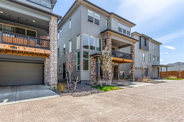 15774 W Girard Ave, Morrison, CO 80465 - view of front of house with driveway, stone siding, and an attached garage