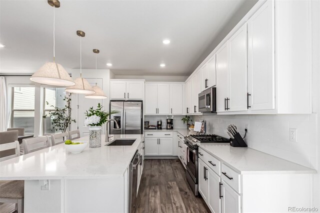 15774 W Girard Ave, Morrison, CO 80465 - kitchen featuring appliances with stainless steel finishes, a breakfast bar, white cabinets, decorative backsplash, and a sink
