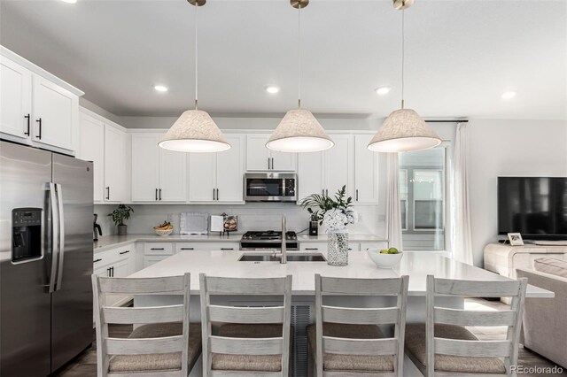 15774 W Girard Ave, Morrison, CO 80465 - kitchen featuring an island with sink, recessed lighting, appliances with stainless steel finishes, light countertops, and a sink
