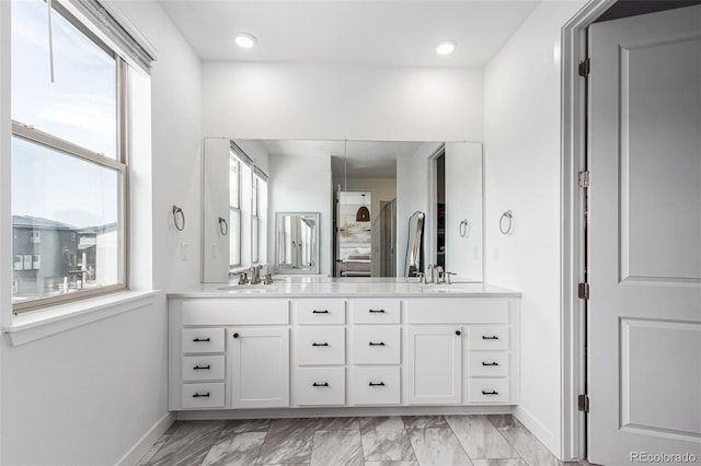 15774 W Girard Ave, Morrison, CO 80465 - bathroom with double vanity, marble finish floor, a sink, and baseboards