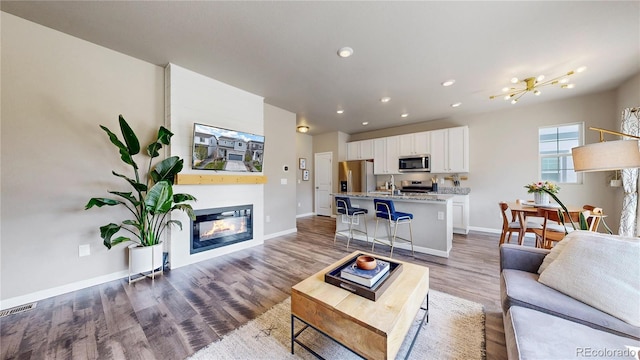 1933 Villageview Ln, Castle Rock, CO 80104 - living area with baseboards, recessed lighting, wood finished floors, and a glass covered fireplace