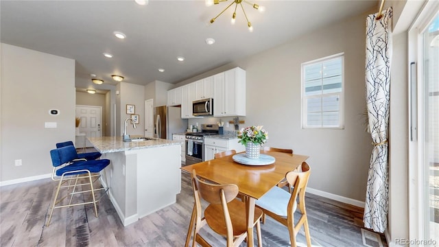 1933 Villageview Ln, Castle Rock, CO 80104 - kitchen featuring stainless steel appliances, baseboards, a kitchen island with sink, white cabinets, and recessed lighting