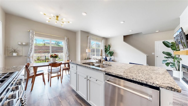 1933 Villageview Ln, Castle Rock, CO 80104 - kitchen featuring appliances with stainless steel finishes, a sink, light stone countertops, wood finished floors, and recessed lighting