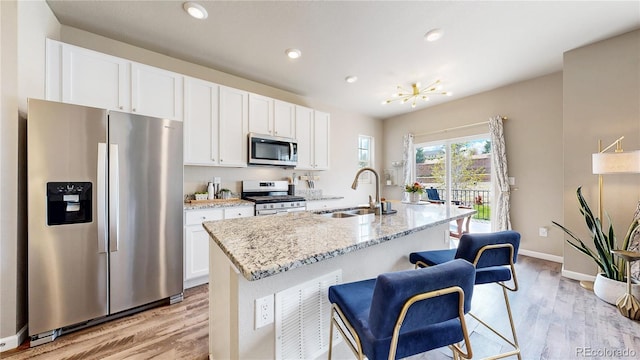 1933 Villageview Ln, Castle Rock, CO 80104 - kitchen featuring stainless steel appliances, a sink, light wood finished floors, white cabinetry, and recessed lighting