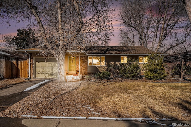 single story home with a garage and a yard