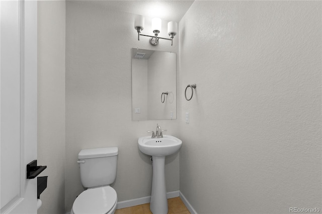 10578 E Jewell Ave, Aurora, CO 80012 - half bath featuring toilet, tile patterned floors, a sink, and baseboards
