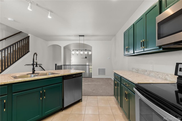 10578 E Jewell Ave, Aurora, CO 80012 - kitchen with stainless steel appliances, a sink, green cabinetry, and light colored carpet