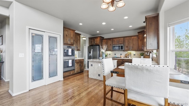 11818 Rio Secco Rd, Peyton, CO 80831 - kitchen with stainless steel appliances, light wood-type flooring, light countertops, decorative backsplash, and recessed lighting