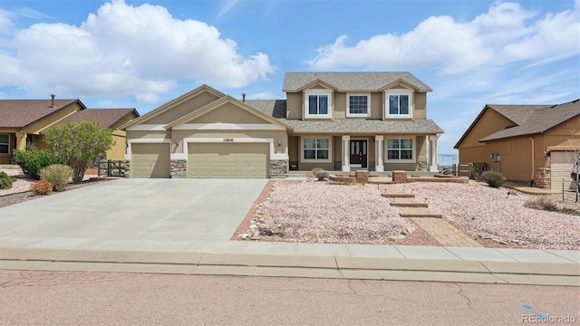 11818 Rio Secco Rd, Peyton, CO 80831 - view of front of property featuring stucco siding, an attached garage, a porch, driveway, and stone siding