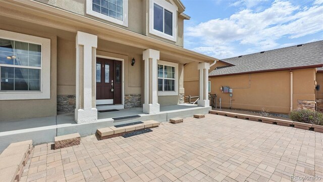 11818 Rio Secco Rd, Peyton, CO 80831 - doorway to property with stucco siding, covered porch, and stone siding