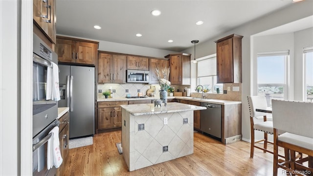 11818 Rio Secco Rd, Peyton, CO 80831 - kitchen with appliances with stainless steel finishes, backsplash, recessed lighting, decorative light fixtures, and light wood-type flooring