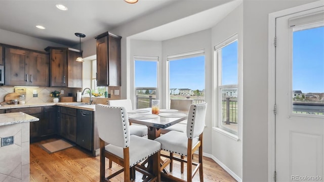 11818 Rio Secco Rd, Peyton, CO 80831 - kitchen featuring a sink, light wood-style floors, tasteful backsplash, decorative light fixtures, and dishwasher