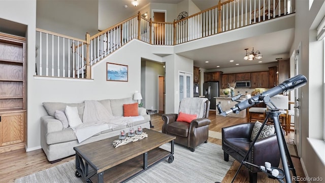 11818 Rio Secco Rd, Peyton, CO 80831 - living room featuring light wood-style flooring, a towering ceiling, baseboards, and recessed lighting