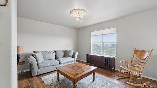 11818 Rio Secco Rd, Peyton, CO 80831 - living room featuring wood finished floors, a chandelier, and baseboards