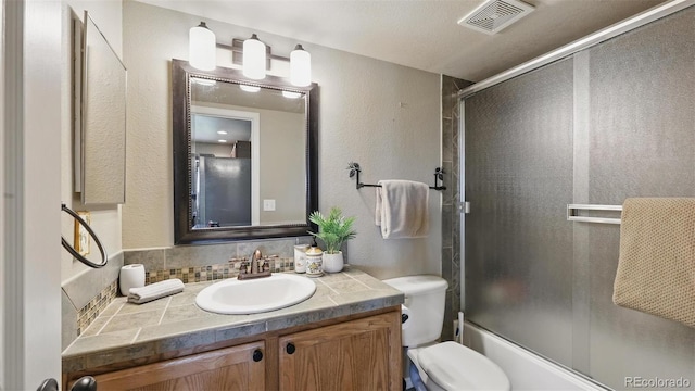 11818 Rio Secco Rd, Peyton, CO 80831 - full bathroom featuring a textured wall, vanity, toilet, bath / shower combo with glass door, and tasteful backsplash