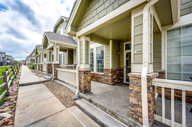 15955 E Geddes Dr Unit 55, Aurora, CO 80016 - view of exterior entry featuring covered porch, a residential view, and stone siding