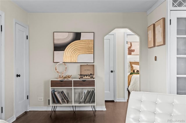 interior space featuring baseboards, arched walkways, and dark wood-style flooring