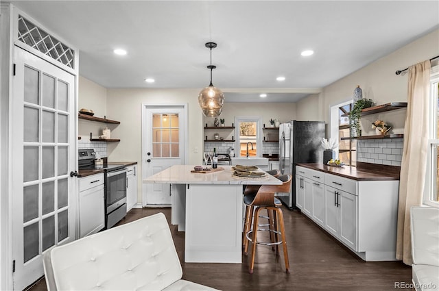 kitchen with dark wood finished floors, stainless steel appliances, and open shelves