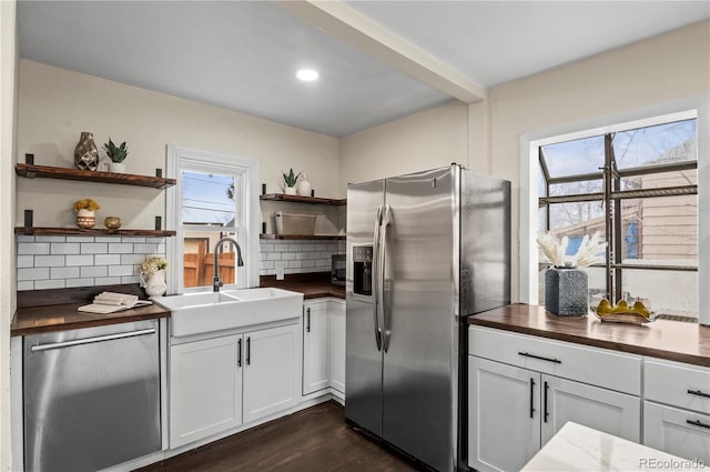 kitchen featuring a sink, open shelves, a wealth of natural light, and stainless steel appliances