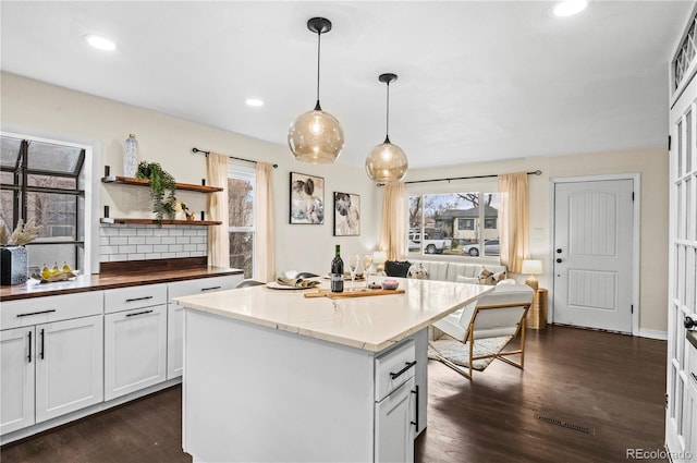 kitchen featuring dark wood finished floors, recessed lighting, pendant lighting, and a center island