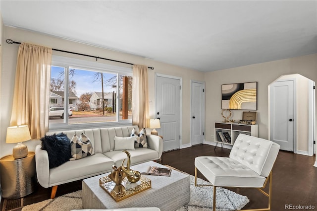 living area featuring baseboards, arched walkways, and dark wood-style flooring