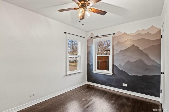 unfurnished room featuring a ceiling fan, wood finished floors, and baseboards