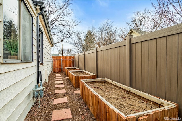 view of side of home featuring a garden and fence