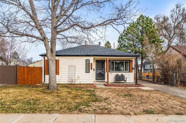 bungalow with a front lawn and fence