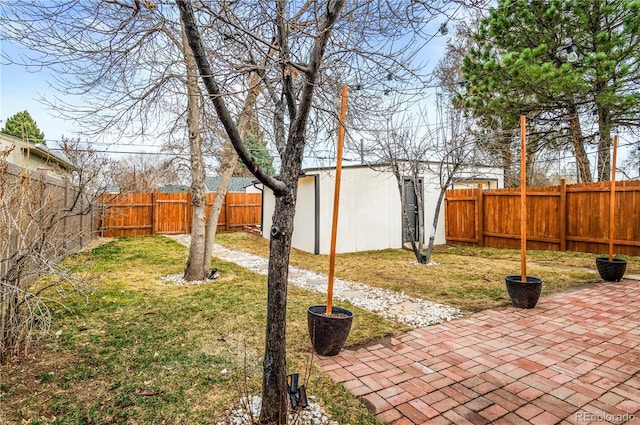 view of yard with an outbuilding, a fenced backyard, and a patio area