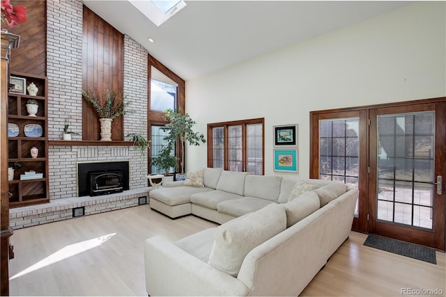 living room featuring high vaulted ceiling, a wealth of natural light, and light wood-style flooring