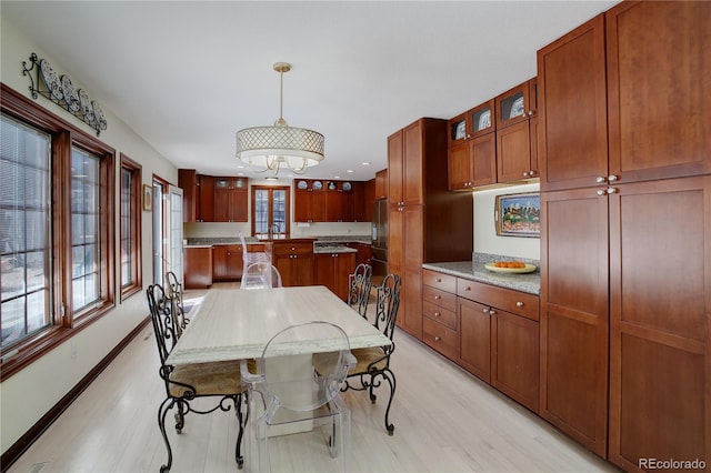 dining area with light wood-style flooring and baseboards