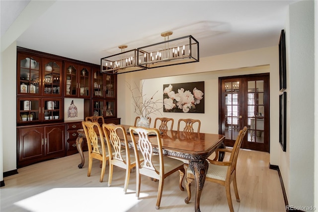 dining space featuring french doors and light wood-style flooring