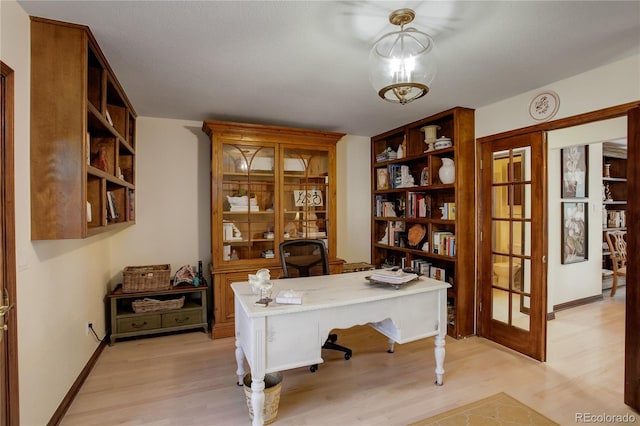 home office with french doors, light wood-type flooring, and baseboards