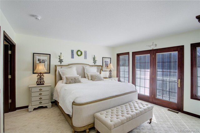 bedroom with light carpet, access to outside, visible vents, and baseboards