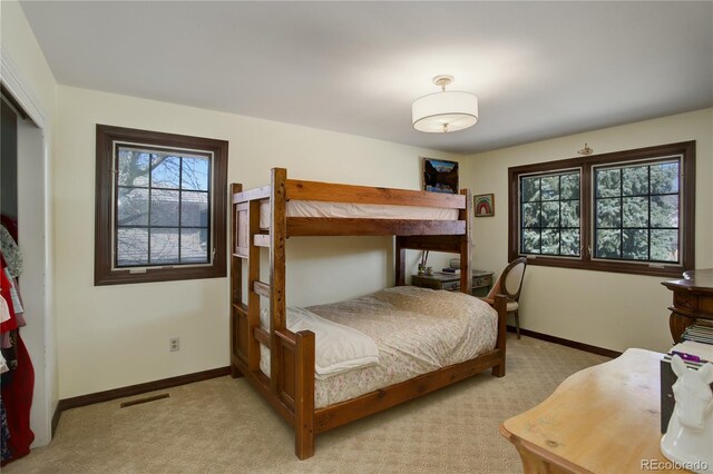 bedroom featuring light colored carpet, visible vents, and baseboards