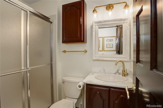 bathroom with toilet, a shower with shower door, and vanity