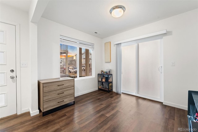 interior space with visible vents, baseboards, and dark wood finished floors