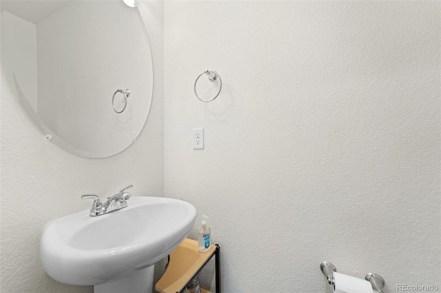 bathroom featuring a sink and a textured wall