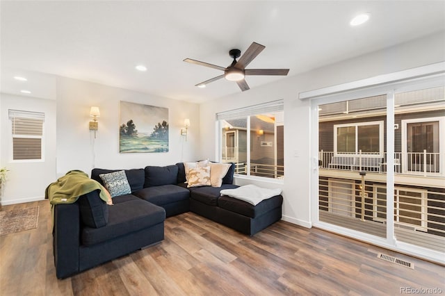 living area featuring visible vents, recessed lighting, baseboards, and wood finished floors