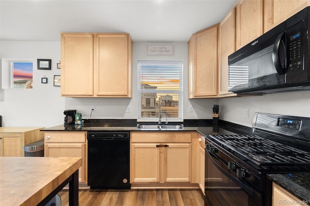 kitchen featuring a sink, black appliances, and light brown cabinetry