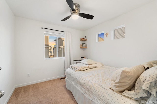 bedroom featuring a ceiling fan, visible vents, light colored carpet, and baseboards