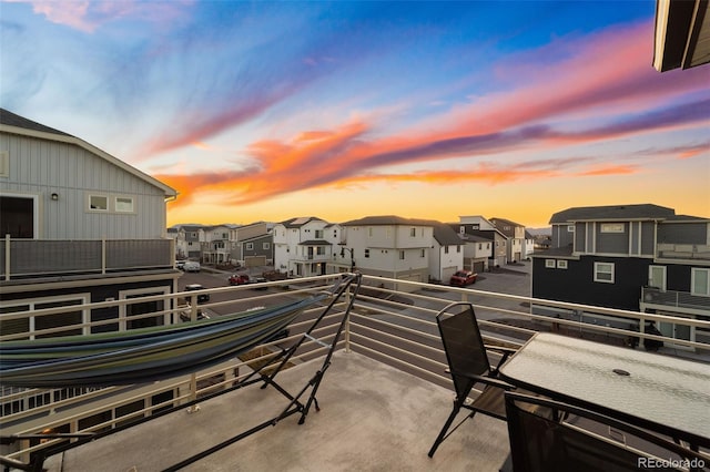 patio terrace at dusk with a balcony and a residential view