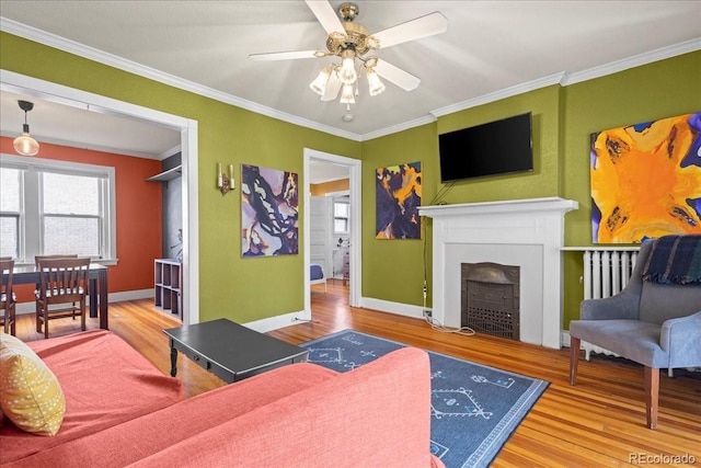 living room with ceiling fan, hardwood / wood-style flooring, and crown molding