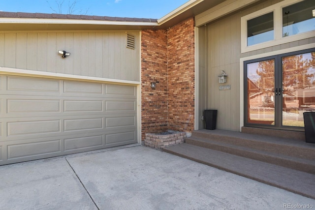 property entrance with french doors, a garage, and driveway