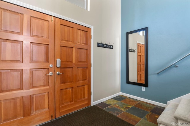 entrance foyer featuring stone tile flooring and baseboards