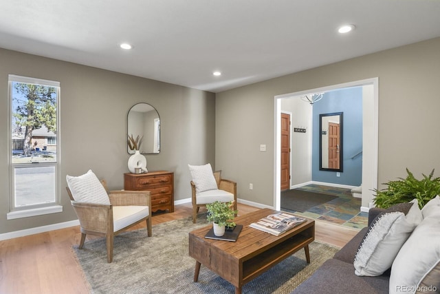 living area with recessed lighting, baseboards, a notable chandelier, and wood finished floors