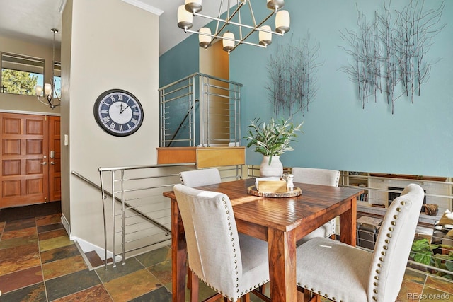 dining space with baseboards, an inviting chandelier, and stone tile flooring