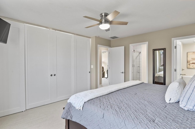 bedroom featuring ensuite bath, visible vents, and ceiling fan