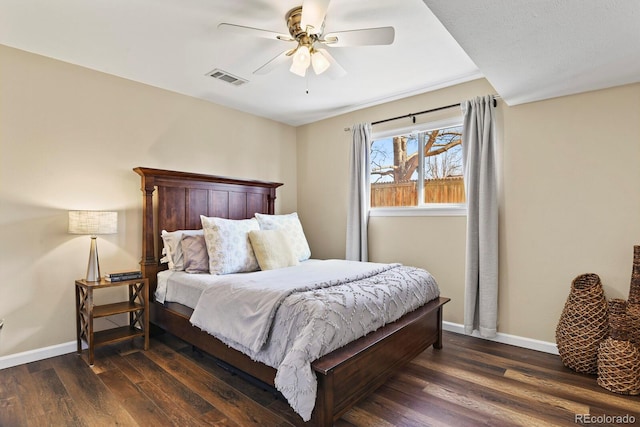 bedroom featuring dark wood finished floors, baseboards, visible vents, and ceiling fan