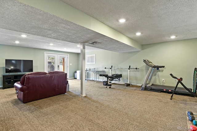 exercise room with baseboards, visible vents, a textured ceiling, and carpet